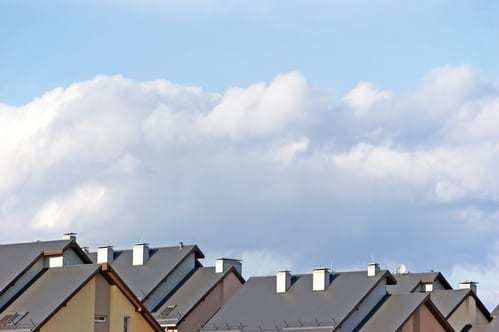 The tops of roofs against a blue sky.