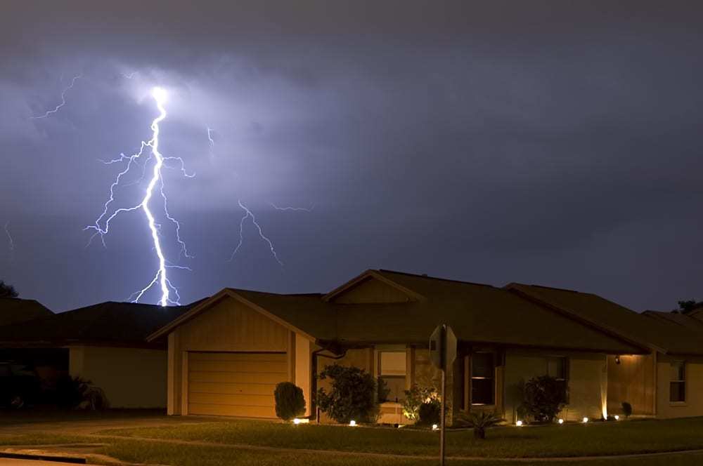 Lightning bolt striking above residential roof