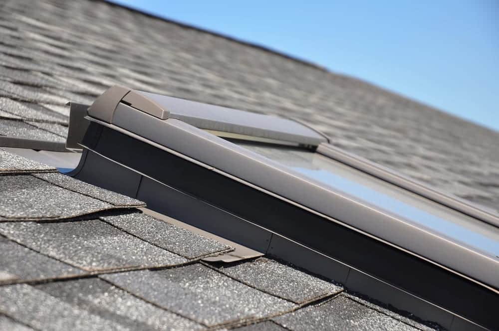 Close-up of skylight on sloped shingled roof