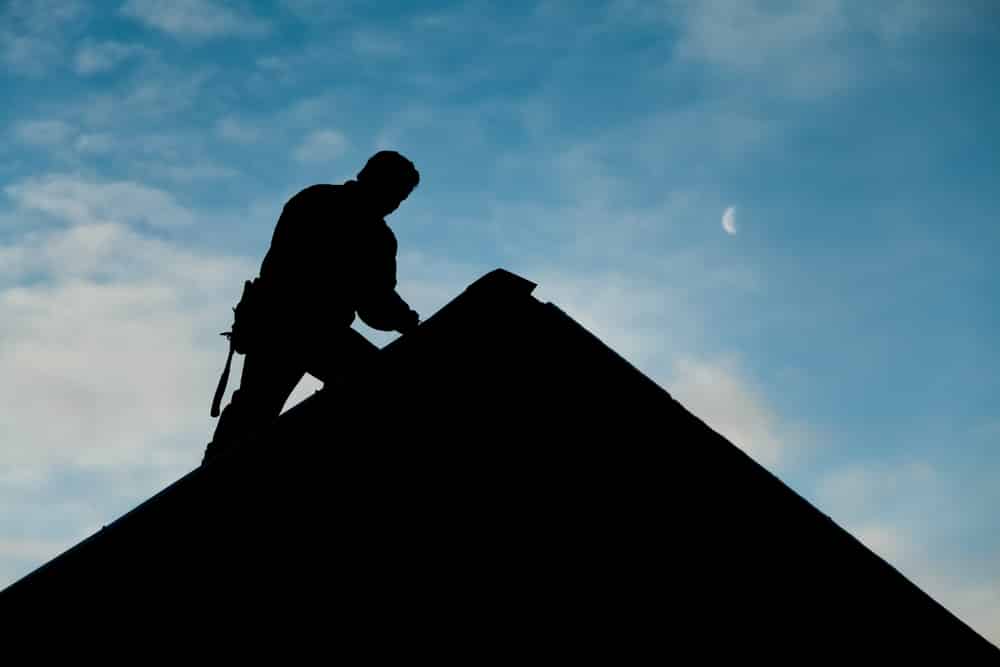 Silhouette of roofer working on roof