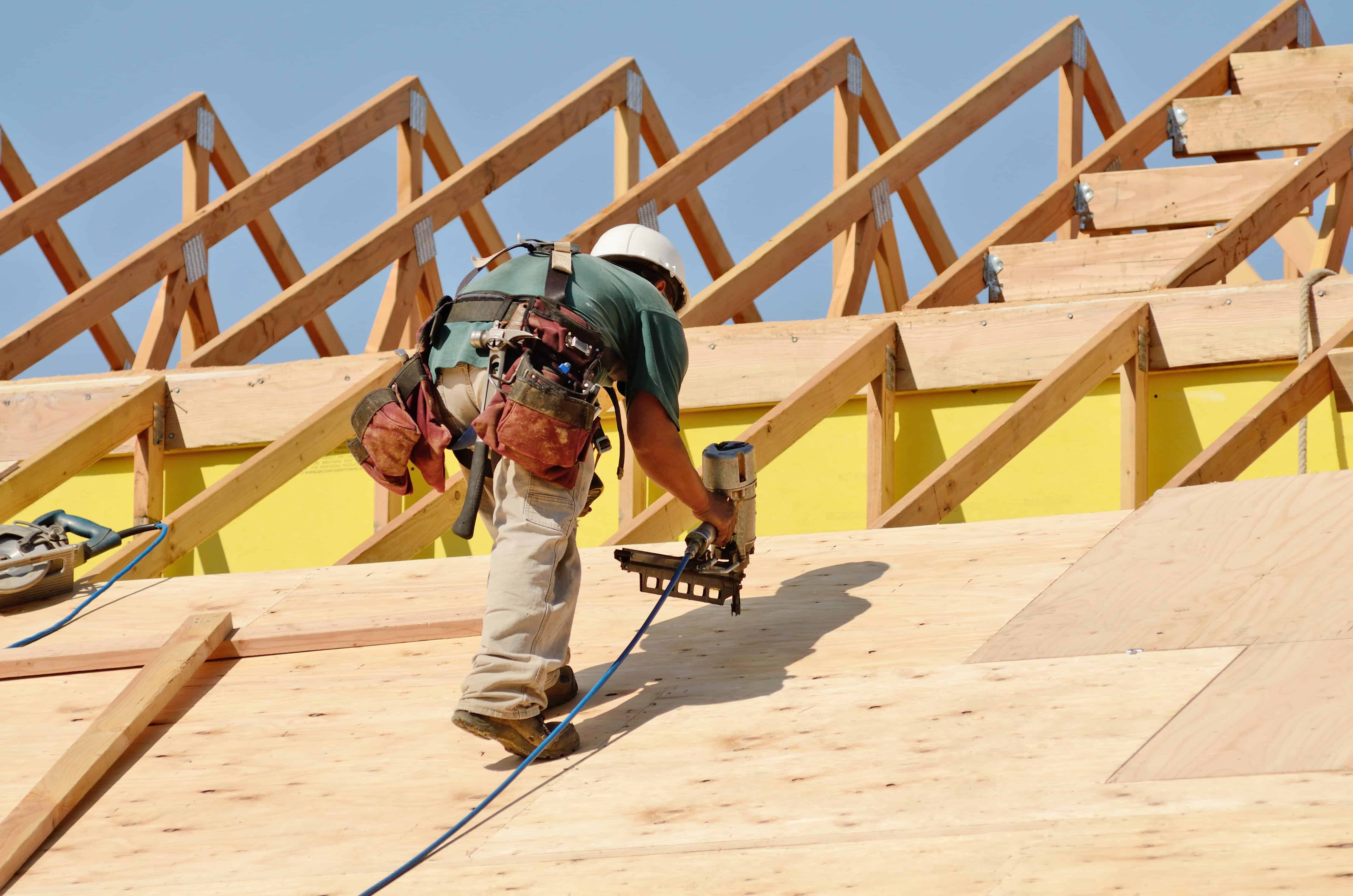 Roofer attaching roof sheet for decking