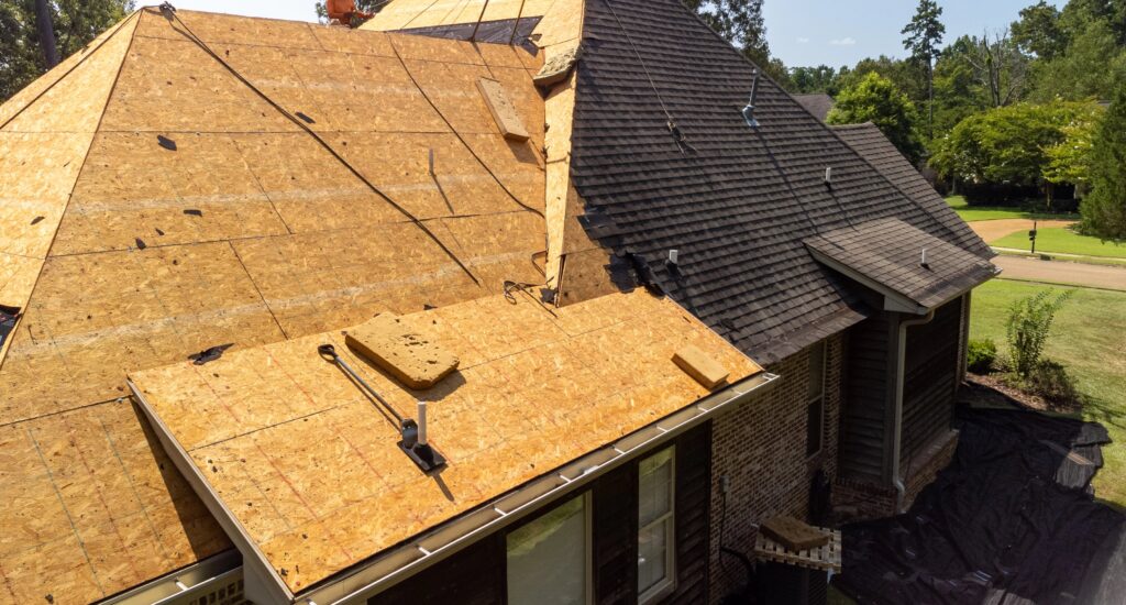 Home roof, decking exposed, new shingles being installed